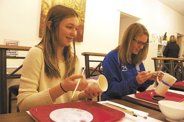 Isabel Barjesteh and Grace Nikunen use their artistic ingenuity to paint two mugs at Heart and Soul