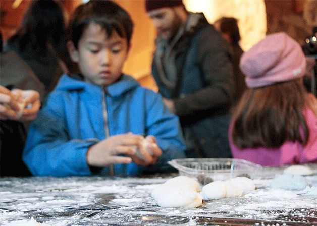 Bing Kawasaki forms a piece of the mashed sweet rice into a mochi ball.