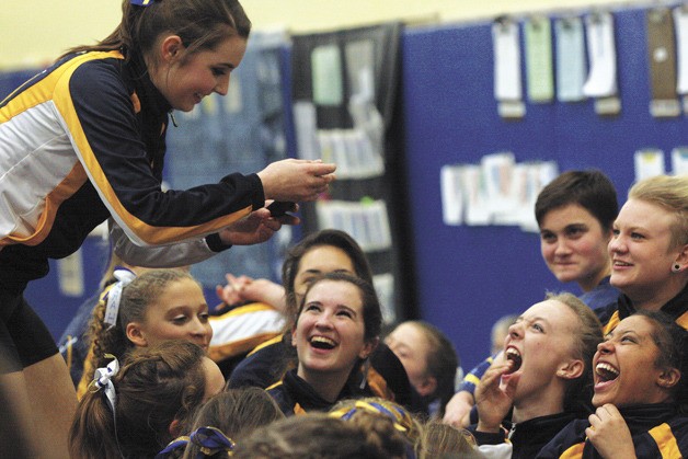 The Spartans share a laugh over a gag portrait on somebody’s iPhone during a break in competition during their final home meet. Bainbridge bounced back from the home meet loss — its first since 2000 — to win the Metro League championship.