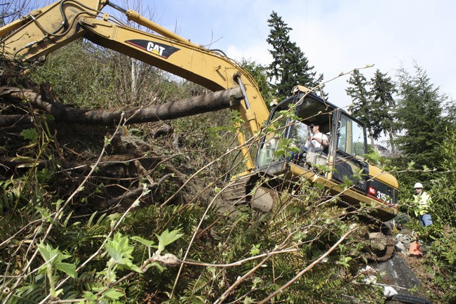 Shawn Liden maneuvers his Caterpillar in a position Saturday to build a stable platform on which to work. With the help of a couple of dump trucks