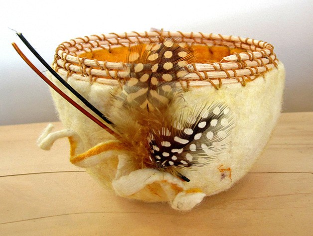 A felted wool basket with speckled feathers