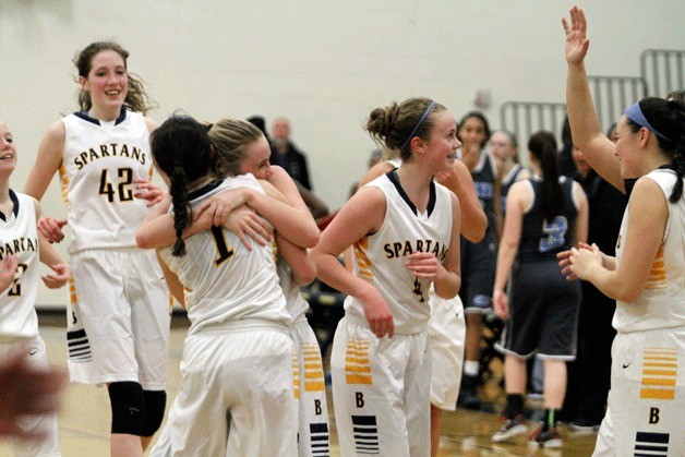 Maddie Ketcheside gets a hug from teammate Kiera Havill after Ketcheside’s late-game heroics lifted the Spartans past the Seahawks in the first round of the Metro Tournament.