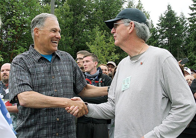 Governor Jay Inslee shakes hands with Tom McCloskey after presenting him with his “Citizen of the Day” pin.