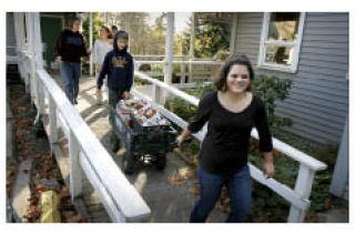 Hyla Middle School student Olivia Marler and her classmates tow a wagon of food into Helpline House Monday.