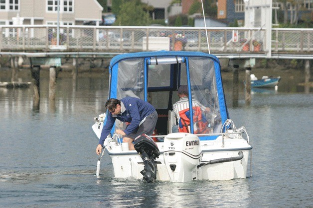 Employees for the Kitsap Public Health District collect water samples in Eagle Harbor near the city dock Monday to determine if a 'no contact' health advisory can be lifted.