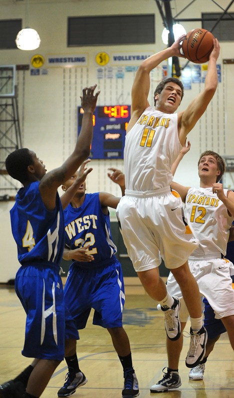 Bainbridge forward John Masla towers over West Seattle for the rebound during home action Tuesday. The Spartans won the match 50-48