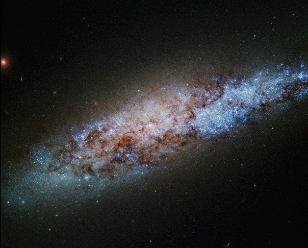 This bundle of bright stars and dark dust is a dwarf spiral galaxy known as NGC 4605