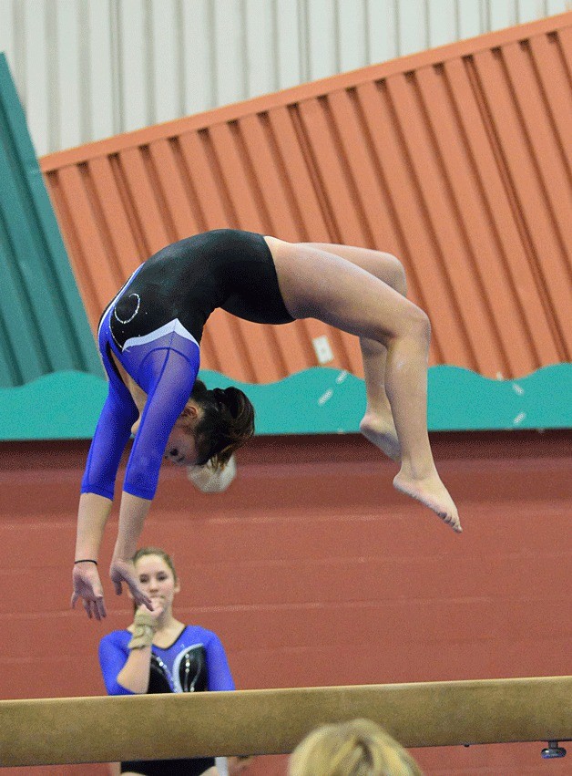 Chloe Seferos competes on the beam during the final home meet for the Bainbridge Island Gymnastics Club girls team. She earned second place in Level 9 competition.