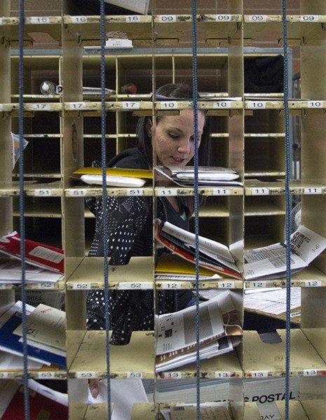 Postal worker Brittney Petito sorts mail at the Bainbridge Island Post Office the morning after Thanksgiving.