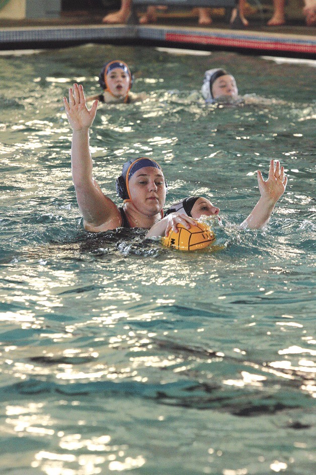 Emily Carson of the Lady Rays thwarts a move to the goal by an OAC swimmer during water polo action earlier this week.