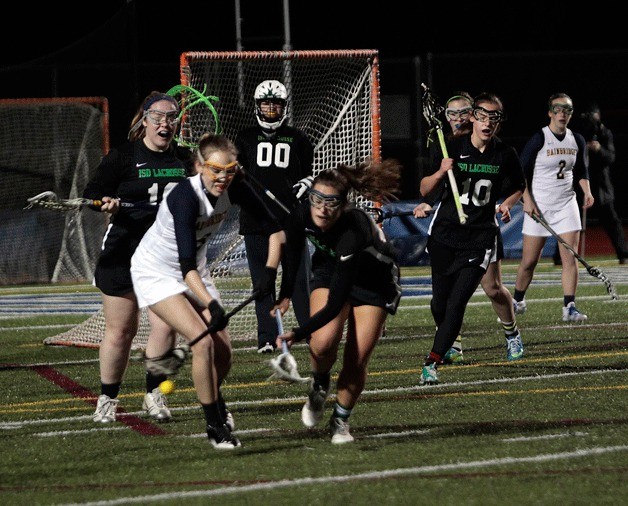 Bainbridge battles Issaquah for possession during the Spartans' 13-7 win in girls varsity lacrosse.