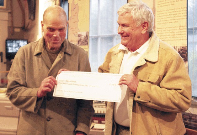 Islander David Ullin is presented his winning check by  historical museum board president Dan Fowler shortly after his name was drawn for first prize.