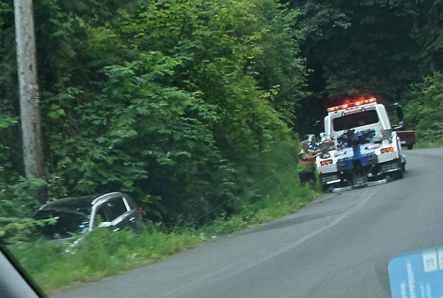 A tow truck operator recovers a vehicle that went off the road on Bucklin Hill Road Friday morning.