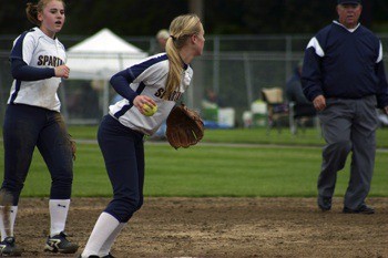 Bainbridge shortstop Lauren Reichert gets into position to throw to first for an out as second baseman Hailey Willman and the bases umpire watch the play during the Spartans' 10-0 win over Mt. Spokane Saturday.