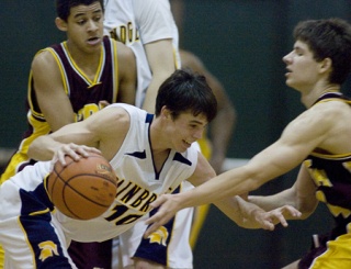 Guard Jimmy Baggett moves the ball past an O’Dea defender during Bainbridge High’s 58-49 win over Metro League rival O’Dea last Saturday in the BHS gym. Baggett scored three points for the Spartans