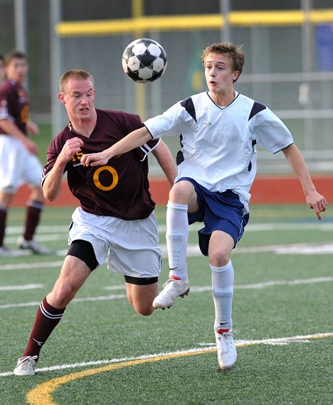 Bainbridge sophomore Connor Winship challenges O'Dea's Jack Ryan for the ball. The Spartans went on to win 8-1.