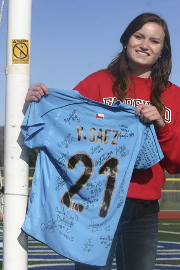 Veronica Saez holds up her goalkeeper kit with signatures from her teammates on the Chile U-17 women’s national team.