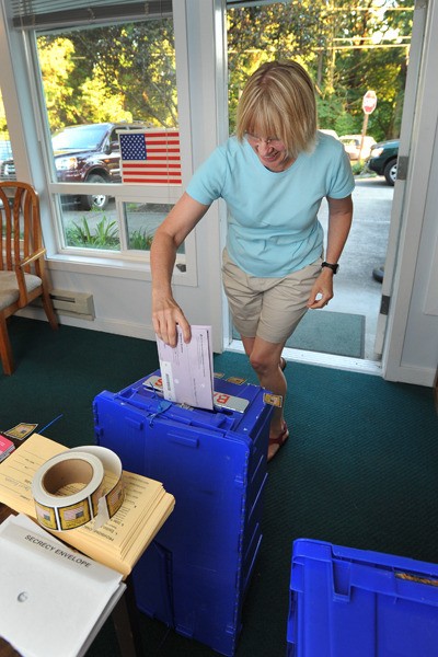 Island voter Becky Eastgard drops her ballot off at the Senior Center Tuesday