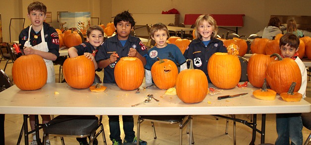 The Cub Scouts of Pack 4545 start carving their jack-o'-lanterns at an earlier pumpkin-carving party.