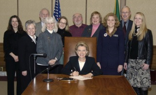 Gov. Christine Gregoire signs HB 1066 on Wednesday with representatives of the Bainbridge City Council