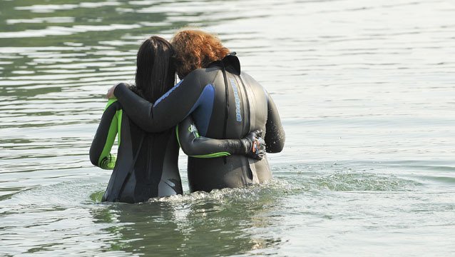 Melanie Sattler and Heather Burger support each other’s entry into Manzanita Bay Wednesday in preparation for Arms Around Bainbridge Aug. 13-15. Sattler