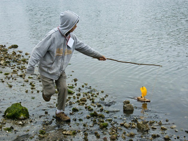 A camper in the Bainbridge Island Historical Museum's “Once Upon a Time” pulls his boat along the water's edge during an earlier history camp. The museum has been honored with an Award of Excellence from the Washington Museum Association for last year's history camp.