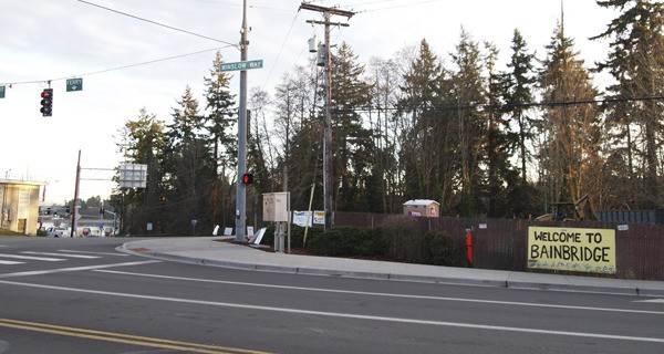 A brown fence covers the site where the Unocal gas station formerly stood at the entrance to downtown Winslow.