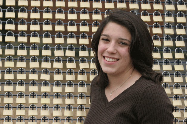 Kimberly MacLeod stands next to her padlock-filled fence.