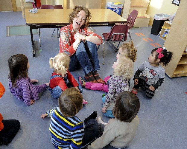 Brad Camp/For the Review Peacock Family Center teacher Mary Zabinski leads a group interaction Wednesday. Peacock hosted a forum of five island child care organizations to help parents compare the different educational theories.