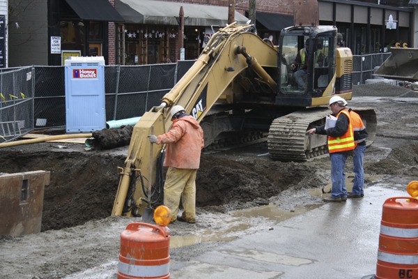 Construction workers dig up contaminated soil on the corner of Winslow Way and Madison Avenue.