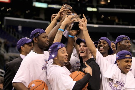 Rudy Sharar (center) and the UW men's basketball team celebrate with the Pac-10 tournament trophy after the Huskies' 79-75 win over California last weekend.