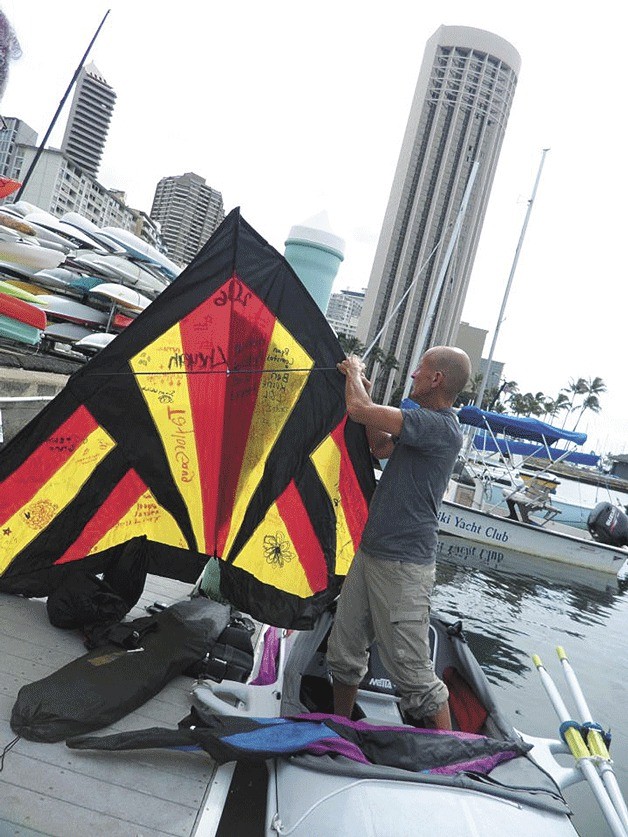 Rory Wilson holds a kite signed by many of his students.