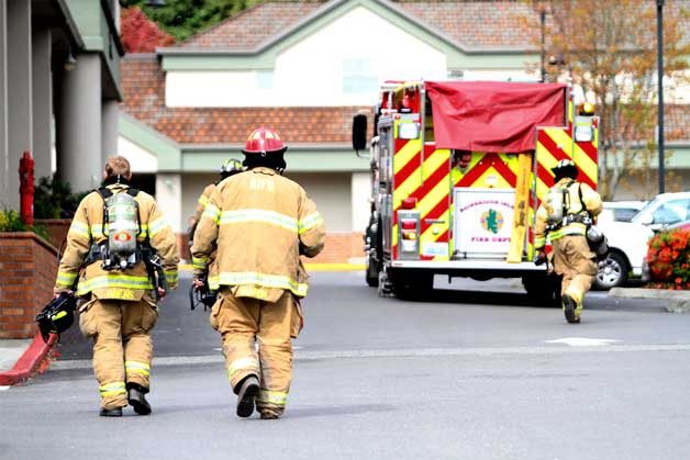 Bainbridge firefighters return to their engine after being called out to the Island Village Shopping Center Wednesday morning.