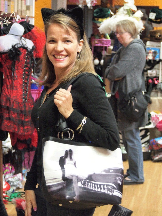 Pretty Stick co-owner Kellie Creamer stands with a unique Harveys SeatbeltBag that features a photograph of Dana and Melanie Harvey