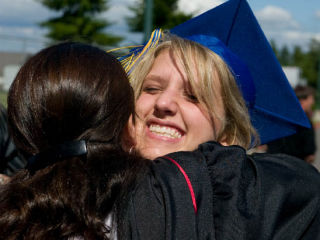 (Counter-clockwise from top right) Graduating senior Allison Mathews hugs one of her favorite teachers before the Bainbridge High School and Eagle Harbor High School’s Class of 2008 commencement ceremonies Saturday; James Slingerland decorated his cap with a soccer cone; Barbara Mycka waves a hand clapper; Emily Luzzo proudly waves her diploma; BHS food services employee Joanne Hoppis