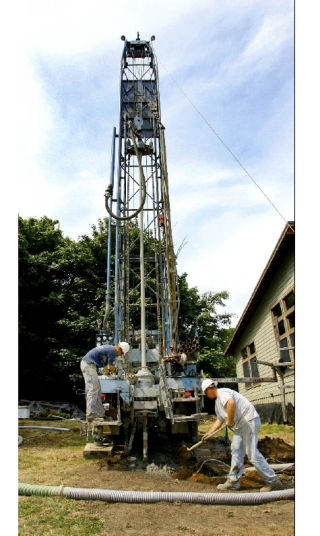 (Top) Chris Gregory of Gregory Drilling maneuvers 300 feet of tubing that will eventually be used to circulate water underground to be warmed by the earth. (Above)Gregory and worker Justin Carter prep the drilling rig to drill one of the five holes for the geothermal system. (Left) Muddy water erupts from the rotary drill bit. (Right) Carter sets the pump for recirculating water used in the drilling process. Together the five holes will yield 70