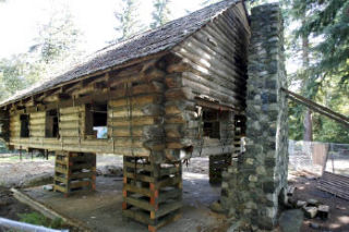 The historic Camp Yeomalt log cabin was lifted by house mover Jeff Monroe this week to allow the installation of fresh logs and a new foundation. The stone chimney will also be straightened.