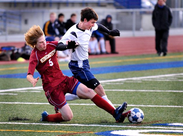 Kingston High School player Ian Chaussee defends for the ball against Bainbridge Island player Jimmy Baggett during action at Bainbridge Memorial Stadium Tuesday.