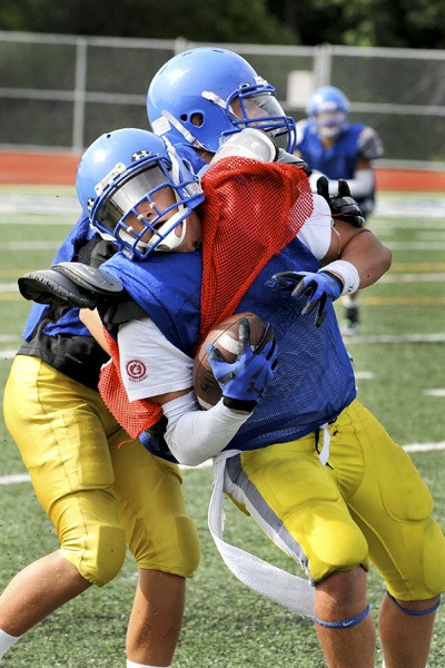 Jason Haley attempts to push through a would-be tackler at practice.