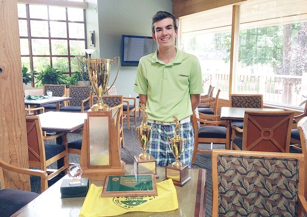 Bainbridge Island golfing standout Sam Warkentin stands next to his trophy and Player of the Year award after winning the Washington Junior Golf Association State Championship.