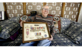 World War II veteran and Pearl Harbor survivor Albert Arcand at home. He joined the Navy at 17 and served aboard the Nevada as a radioman.