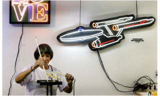 Custom Neon artist Laurie Lewis shapes glass during a demonstration at the studio in Kingston.