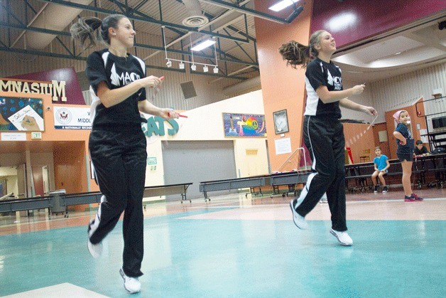 Abigail Harrison and Anna Warga practice their Macy’s Thanksgiving Day Parade routine in the gymnasium of Woodward Middle School in their event uniforms on Monday.