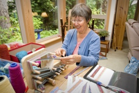 Mary Daley weaves vibrant bookmarks at her table-top inkle loom.