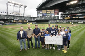 Members of the Bainbridge Island Little League organization stand with representatives of the Building Industry Association of Washington to receive a $5