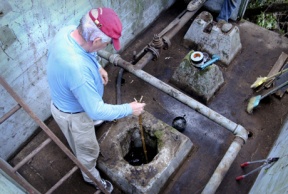 Jerry Elfendahl examines the uncovered well opening on the border of Pritchard Park and the Wyckoff superfund site.