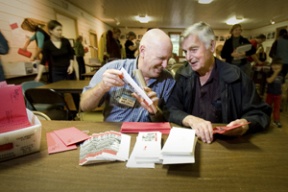 New One Call For All Executive Director Bob Linz (left) and co-founder Ernie Biggs stuff Red Envelopes Friday morning.