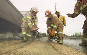 Fire Chief Jim Walkowski (left) displays proper chainsaw technique for cutting a louvre in the exterior flat roof of American Marine Bank Tuesday morning. The 1940s era building will be replaced with a new structure.