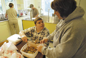 Trepp Hanseth (center) packages doughnuts with Melanie Elliott.