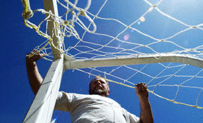 Park district maintenance worker Rob Robinson hangs a soccer net on a goal at Battle Point Park Friday.